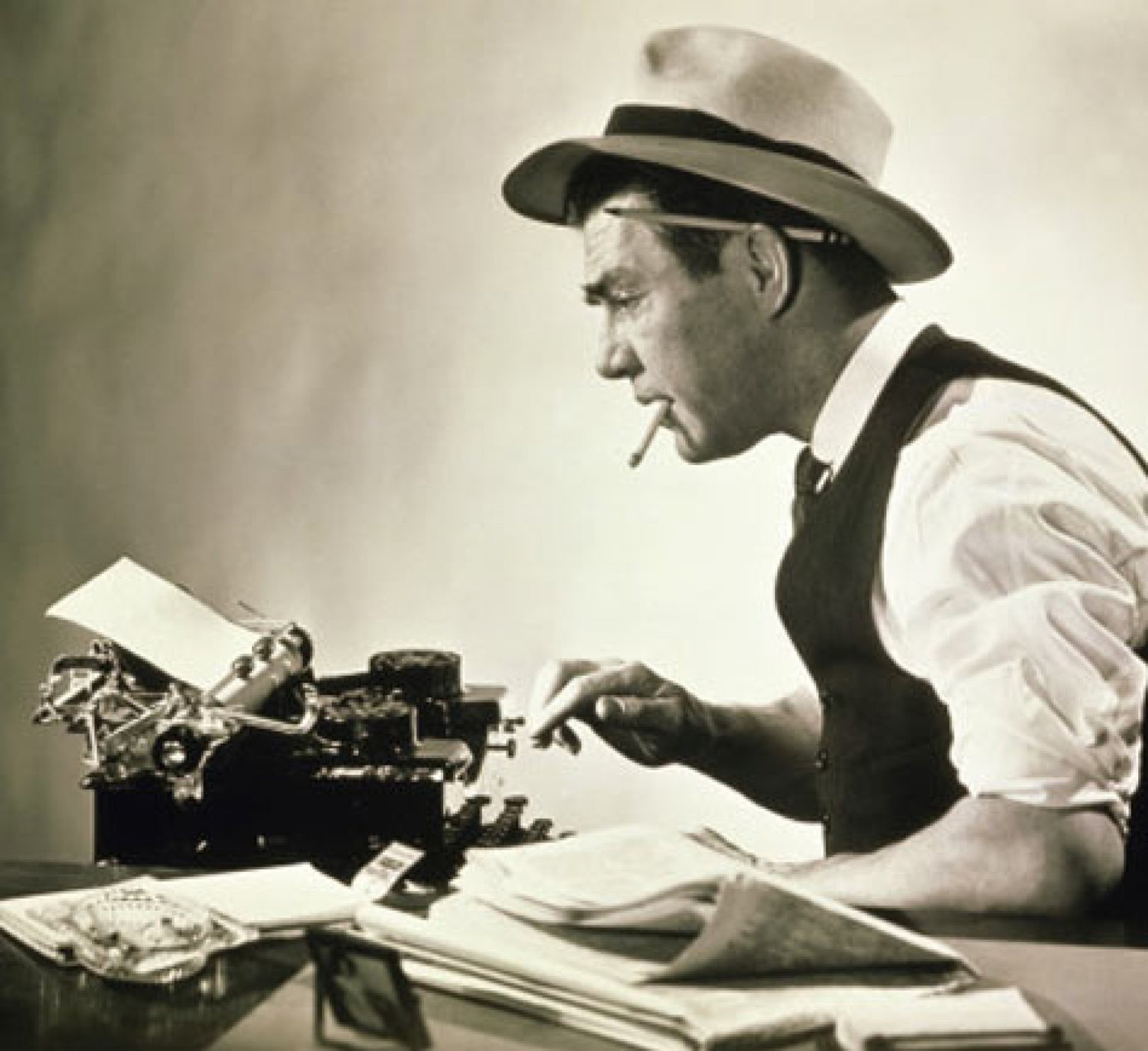 Old school reporter at a typewriter.